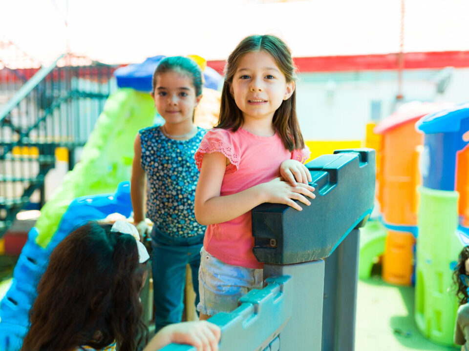 Cute kindergarten girl playing outside the preschool